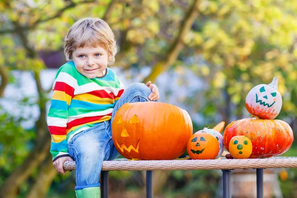 Little kid boy making jack-o-lantern for halloween in autumn gar — Stock Photo, Image