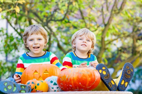 Two little kid boys making jack-o-lantern for halloween in autum — Stock Photo, Image