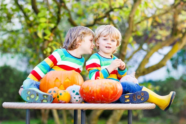 Dois meninos irmãos fazendo jack-o-lanterna para o Halloween em um — Fotografia de Stock