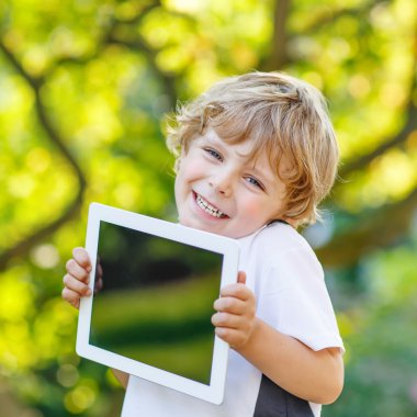 tablet pc, açık havada tutan gülümseyerek mutlu küçük çocuk