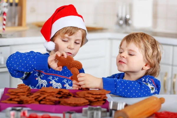 Two little boys baking gingerbread cookies in domestic kitchen — Stok fotoğraf