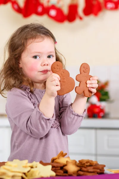 Malá holčička pečení perníku cookie v domácí kuchyni — Stock fotografie