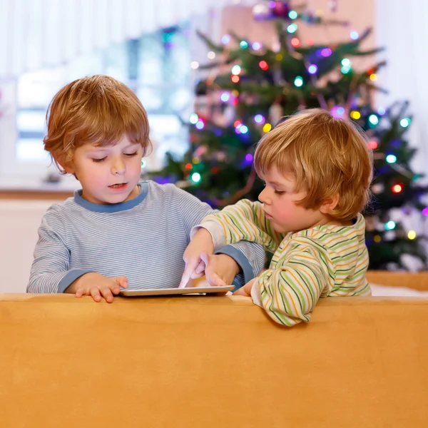 Dwa małe dzieci szczęśliwy gry z komputera typu tablet, wewnątrz — Zdjęcie stockowe