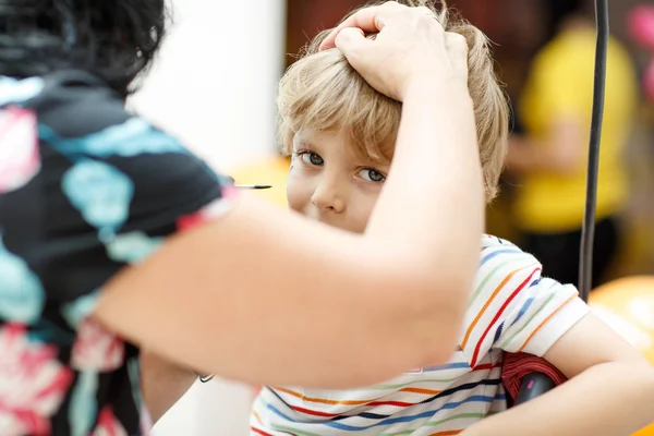 Woman painting face of kid indoors — 스톡 사진