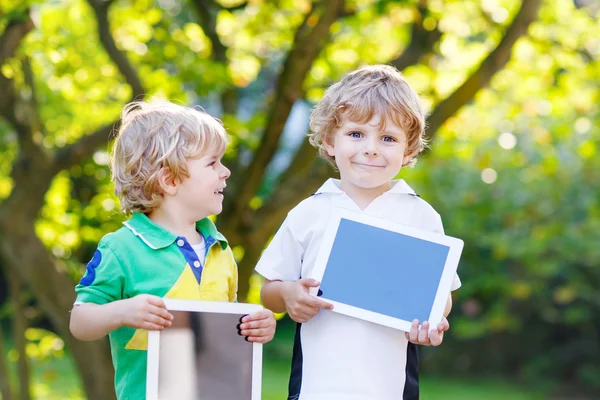 Dos niños pequeños divertidos feliz abount tabletas pc —  Fotos de Stock