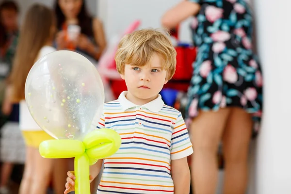 Niño alegre o triste en la fiesta de cumpleaños con un globo aerostático —  Fotos de Stock
