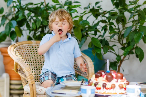 Little boy celebrating his birthday in home's garden with big ca — Stock Photo, Image