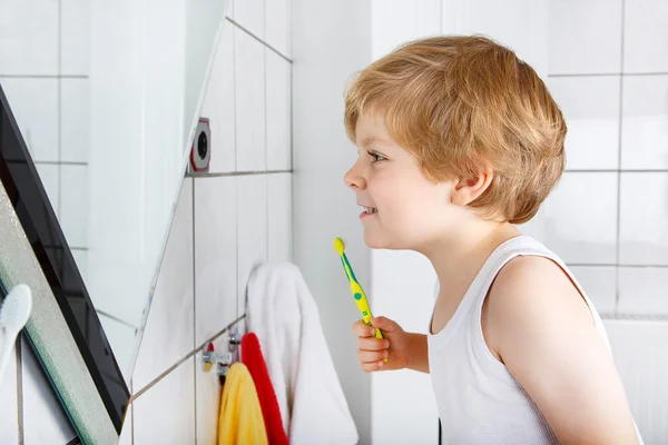 Precioso niño pequeño cepillándose los dientes, en el interior — Foto de Stock