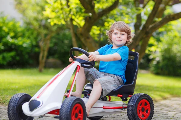 Ativo menino se divertindo e carro de corrida de brinquedo de condução — Fotografia de Stock