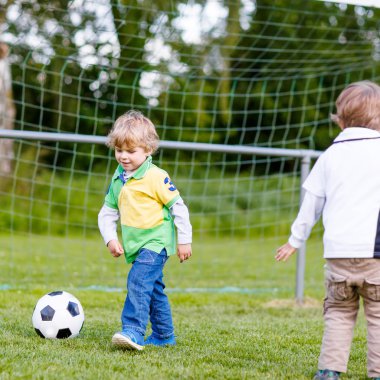 Futbol ve futbol oynayan iki küçük kardeş erkek