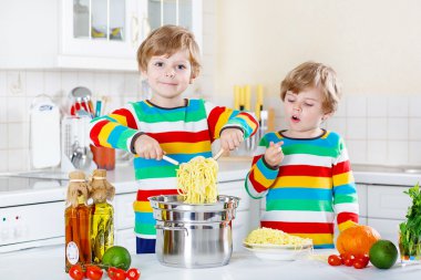 İki küçük çocuklar yerli mutfakta spagetti yiyen çocuk.