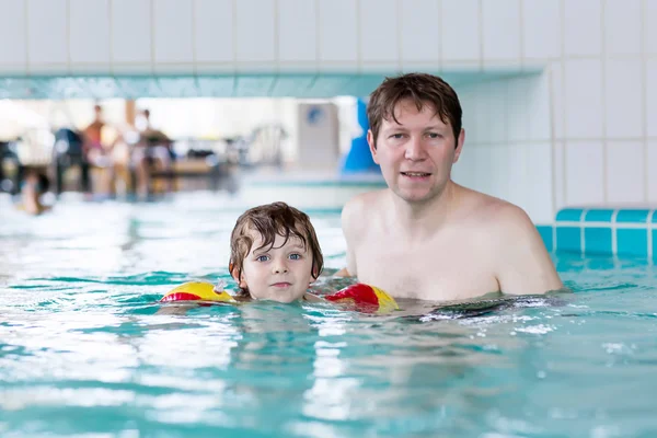 Giovane papà insegnare il suo piccolo figlio a nuotare in casa — Foto Stock