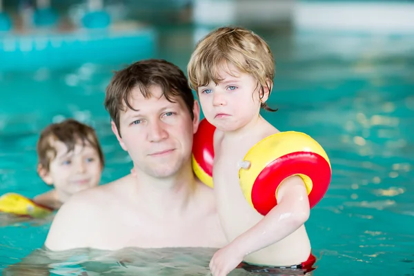 Giovane papà insegna ai suoi due piccoli figli a nuotare in casa — Foto Stock