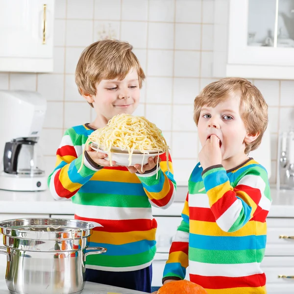 Két kis gyerek fiú eszik spagetti hazai konyha. — Stock Fotó