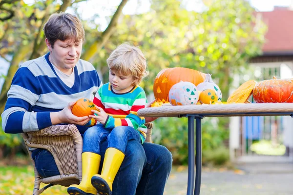 Criança e seu pai fazendo jack-o-lanterna para o dia das bruxas — Fotografia de Stock