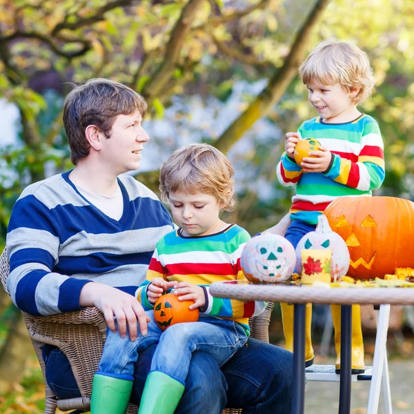 Young dad and two little kids making jack-o-lantern — Stockfoto