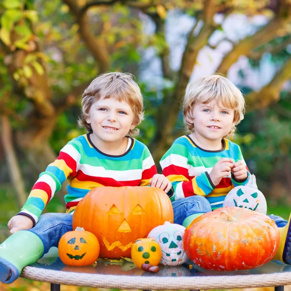 Two little friends boys making jack-o-lantern for halloween in a — Stock Photo, Image