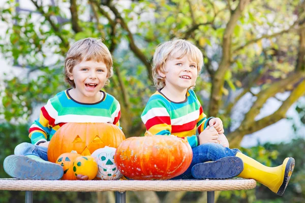 Dua teman kecil anak laki-laki membuat jack-o-lantern untuk Halloween dalam — Stok Foto