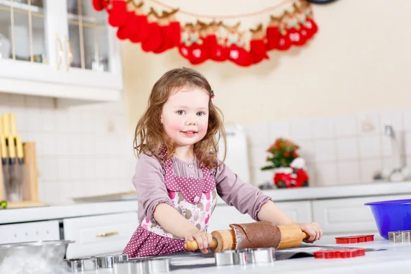 Liten flicka baka pepparkakor i inhemska kök — Stockfoto