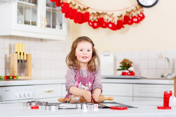 Liten flicka baka pepparkakor i inhemska kök — Stockfoto