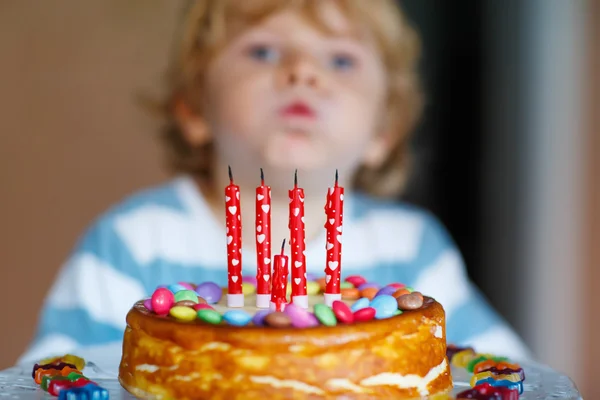 子供の彼の誕生日を祝って、ケーキの上の蝋燭を吹く少年 — ストック写真