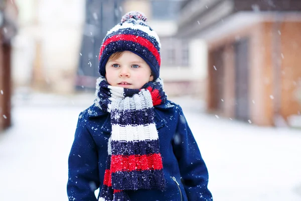 Liten gutt som leker med snø om vinteren, ute . – stockfoto