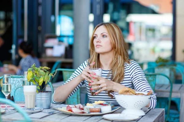 Jeune femme prenant un petit déjeuner sain dans un café extérieur — Photo