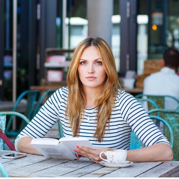 Mujer bebiendo café y leyendo libro en la cafetería —  Fotos de Stock