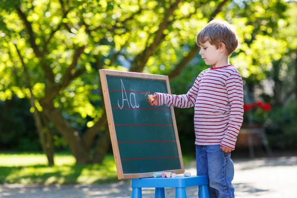 Petit garçon au tableau noir pratiquant les mathématiques — Photo