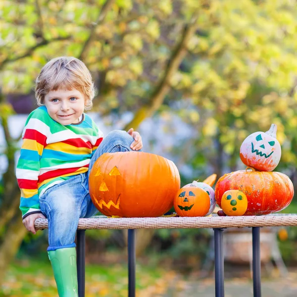 Little kid boy making jack-o-lantern for halloween in autumn gar — Stock Photo, Image