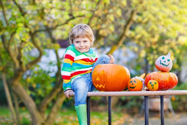 Little kid boy making jack-o-lantern for halloween in autumn gar — Stock Photo, Image