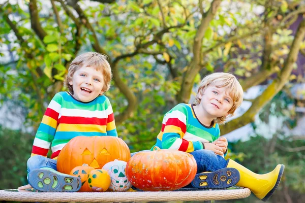 Two little sibling boys making jack-o-lantern for halloween in a — Stock Photo, Image