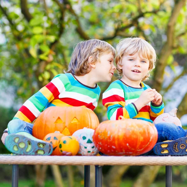 Doi băieți frați mici care fac jack-o-lantern pentru Halloween într-o — Fotografie, imagine de stoc