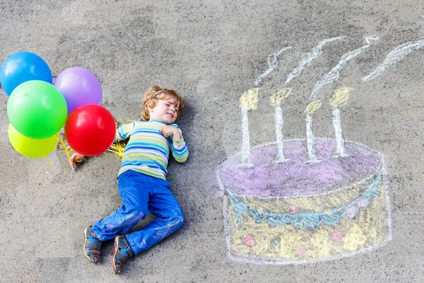 Garoto se divertindo com desenho de bolo de aniversário colorido com chal — Fotografia de Stock