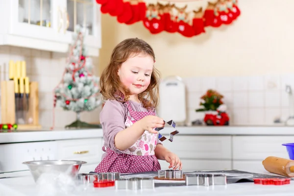 Liten flicka baka pepparkakor i inhemska kök — Stockfoto