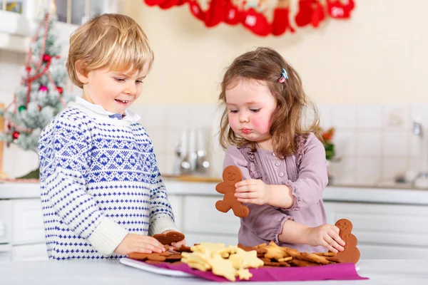 Little boy and girl, siblings, baking gingerbread cookies in domestic kitchen — ストック写真