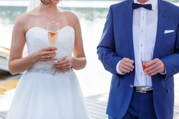 Bride and groom holding a glass of champagne — Stock Photo, Image