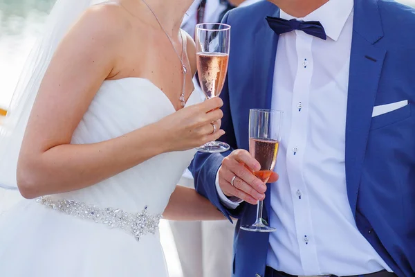 Bride and groom holding a glass of champagne — Stock Photo, Image