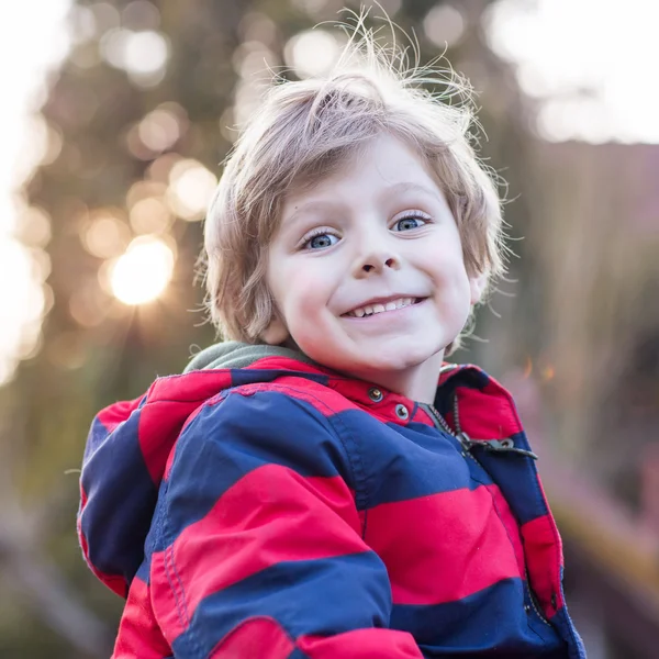Retrato de niño feliz niño en chaqueta roja, al aire libre —  Fotos de Stock