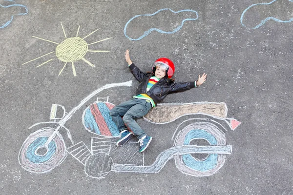 Malé dítě v přilbě s obrázkem motocykl kreslení s colo — Stock fotografie