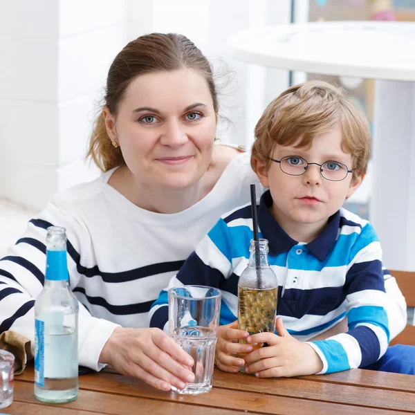 眼鏡と飲み物を楽しむ母親の小さな男の子 — ストック写真