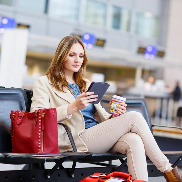 Frau am internationalen Flughafen, liest E-Book und trinkt Kaffee — Stockfoto