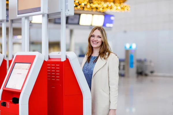 Жінка в міжнародному аеропорту, реєстрація на електронних терміналах — стокове фото