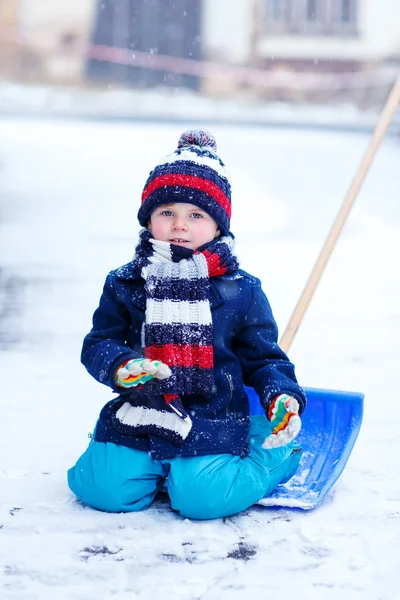 Liten pojke leker med snö på vintern, utomhus. — Stockfoto