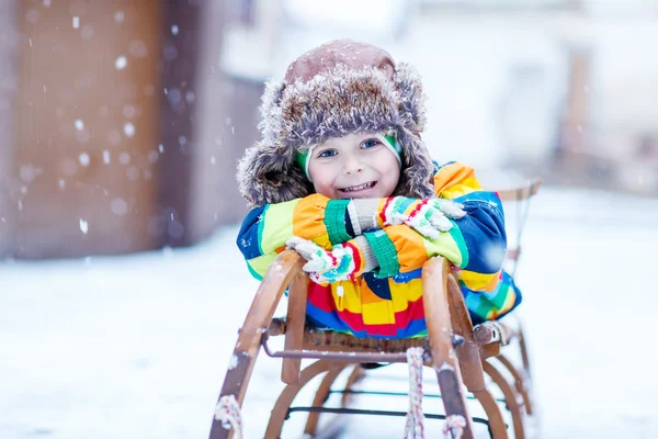 Söt liten rolig pojke i färgglada vinterkläder har roligt med — Stockfoto