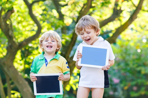 Dwie śmieszne małe dzieci szczęśliwy abount tablety pc — Zdjęcie stockowe