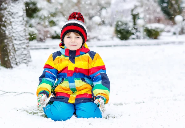 Funny preschool boy in colorful clothes happy about snow, outdoo — Stock Photo, Image