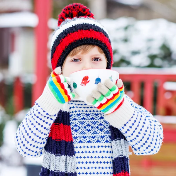 Divertido niño pequeño sosteniendo gran taza con copos de nieve y choco caliente —  Fotos de Stock