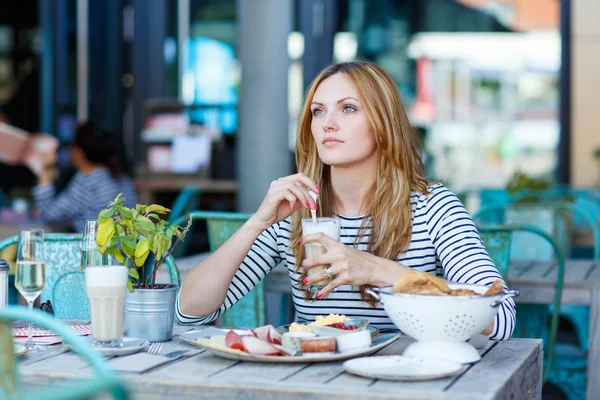 Jeune femme prenant un petit déjeuner sain dans un café extérieur — Photo
