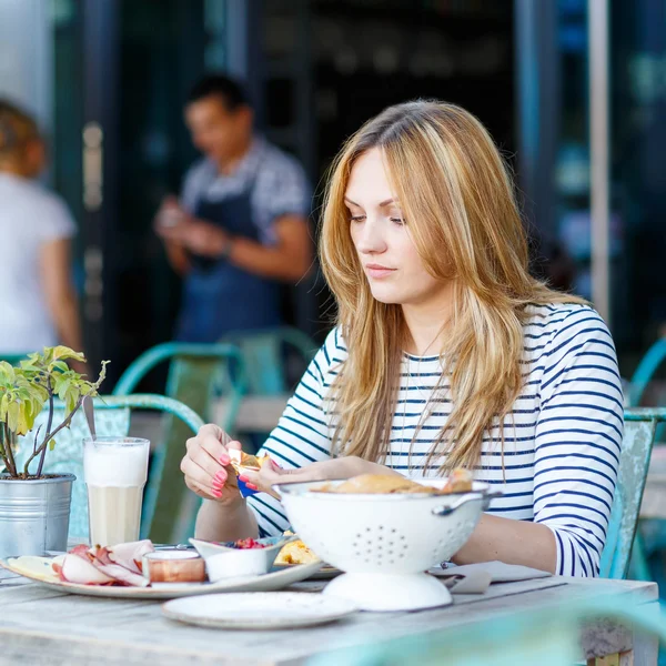 Genç kadın açık kafede sağlıklı kahvaltı — Stok fotoğraf